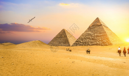 日落时在伟大的埃及金字塔附近的骑手金字塔附近的骑手沙漠目地非洲人图片