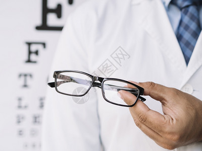 正面镜片男医生拿着一副眼镜他的手分辨率和高质量的美丽照片男医生拿着一副眼镜他的手高品质和分辨率的美丽照片概念想象图片