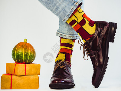 美丽的南瓜带红色丝的礼物有红色丝的美甲时装整齐的双腿旧鞋和明亮多色袜子白背景孤立紧凑的假日时尚优雅的美丽南瓜和时装般的双腿秋天老图片