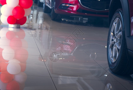 工厂有选择地关注停在现代展厅的汽车轮和新红色汽轮胎并反思瓷砖地板和气球以及汽车工业危机在展厅推广销售概念汽车工业危机可选择的内部图片