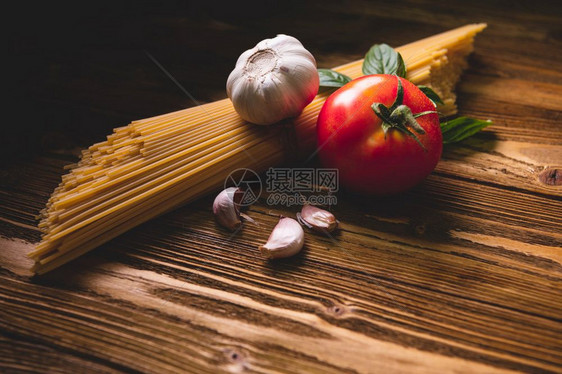 经典的美味意大利面条配料用于厨房烹饪在棕色木桌上放番茄大蒜和罗勒食物餐自制意大利食谱顶视图上方帕尔马干酪多于图片