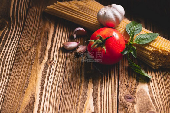美味的意大利面条配料用于厨房烹饪在棕色木桌上放番茄大蒜和罗勒食物餐自制意大利食谱顶视图上方通心粉一顿饭木板图片