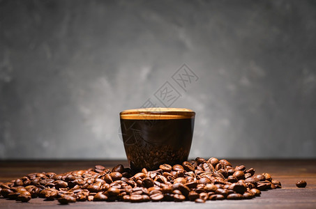 杯浓咖啡特制有选择焦点在灰色桌上加含芳香泡沫和烤豆的咖啡子油炸最小的图片