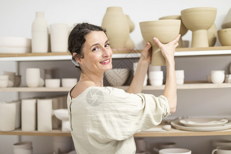 女工作室拥有手制的陶瓷品室内年轻女铁丝网艺人手制泥土品的陶器概念有创造力的图片