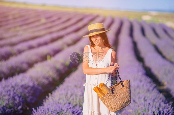 优雅的草本穿紫花衣漂亮年轻女子穿着白裙和帽穿白衣服戴帽子的紫花朵农村图片