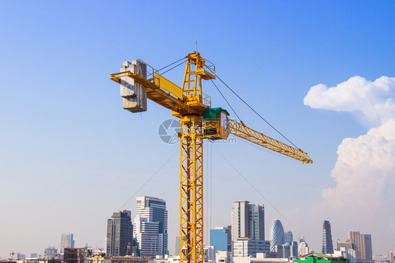 结构体用过的金属丝Craner用于在蓝色天空和白云下建造大型工业具的高楼建筑Crane用于建造高空筑图片
