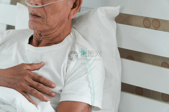 躺在医院床上并带有鼻喉呼吸管的老人图片