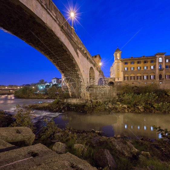 台伯河晚间费布里修斯桥和蒂贝尔岛意大利罗马发光的河图片