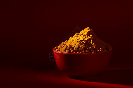 勺子红色背景中碗的干姜黄粉和根或树皮曼贾尔印度图片