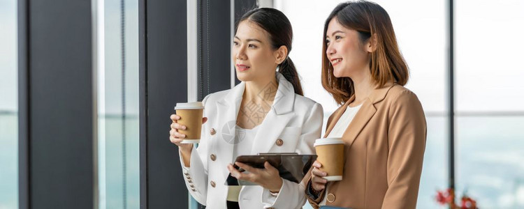 幸福在现代办公室或合用空间咖啡休息放松和谈话商业人际伙伴关系概念期间发言的两名亚洲女商人的Banner网页或封面样板模或者友谊图片