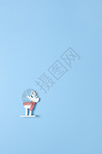 圣诞装饰玩具白鹿在面纸蓝背景的围巾上打字玩具白鹿并复制空间节日新年概念垂直平淡地风格断然十二月最小图片