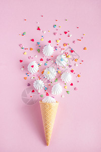 花束丰富多彩的墙纸薄饼冰淇淋甜瓜带散落的白扭曲蛋和粉红背景的糖果装饰品图片