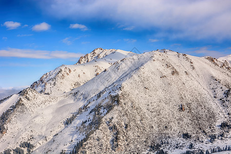 冰旅行首脑在吉尔斯坦公园背景中与森林和积雪的山顶形成高风景脉观以及林和雪地峰顶图片