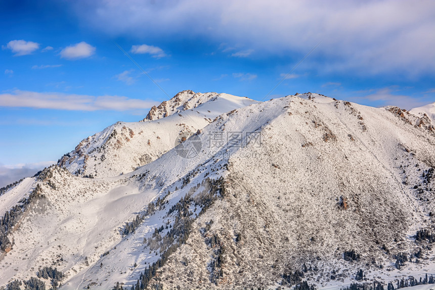 冰旅行首脑在吉尔斯坦公园背景中与森林和积雪的山顶形成高风景脉观以及林和雪地峰顶图片