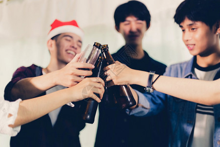 叮当闪发光的人们亚洲朋友团体与有聚会酒精啤饮料和年轻人享受在酒吧敬鸡尾软糖的焦点图片