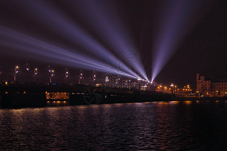 灯Akmens桥横渡道加瓦河的蓝色亮光从对面投射的蓝光点束图像水平的目地图片