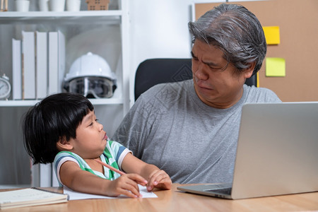 新的亚洲父亲试图在家庭办公室用笔记本电脑与一个陷入混乱的女儿一起工作在隔离期间新式的生活方正常留在家中的概念自由职业和父亲概念是图片