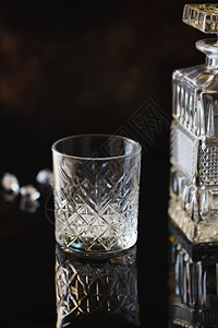 用于威士忌或波本的空玻璃杯和黑色反射表面背景上的晶体方除尘器老的寒冷混合图片