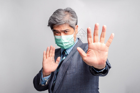 亚洲商人的有选择手焦点用外科医疗面具看着照相机并举起手来禁止传染病预防概念COVID192031肖像可选择的领导图片