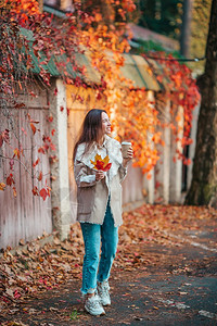 金发女郎十月华丽的秋天公园美丽女子在秋天公园喝咖啡的美丽女子在秋天树叶下图片