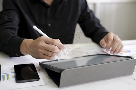 现代的在数字笔记本上写的特质笔结人在办公室网络设计师从事无纸业务技术的项目时触摸电脑平板屏幕操作笔记本电脑启动手指图片