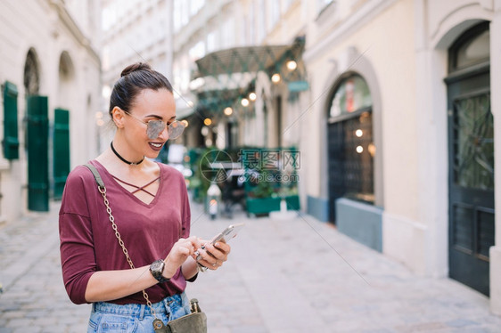 景观电话欧洲街头拥有智能手机的快乐女在城市用智能手机聊天年轻有吸引力的意大利城市户外旅游者在意大利城外酒吧图片