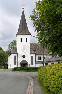 施马伦贝格北德国施马伦堡Sauerland村Westfeld中央街道一带教区堂旧建筑和树的景象图片