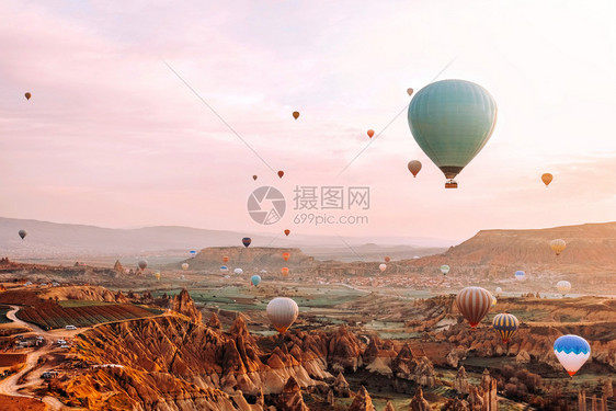 美丽的假期在卡帕多西亚山谷上空飞行的多彩热气球在土耳其流行旅目的地Capapadocia日出时飞过山谷卡帕多奇图片