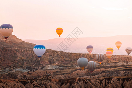 冒险在卡帕多西亚山谷上空飞行的多彩热气球在土耳其流行旅目的地Capapadocia日出时飞过山谷运输烟囱图片