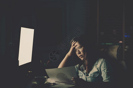 过度劳累集中注意力年轻的亚洲女商人坐在桌子上辛勤工作晚点在场所的电脑桌面前认真行动努力工作太迟的概念AfricaBusiness图片