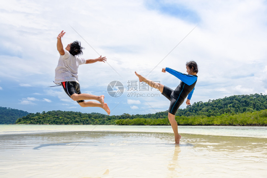 享受快乐的亚州夫妇玩活动一起好的活动女人展示了挑逗姿势踢一个男人在离科利佩岛附近的高拉维海滩上跳到远处塔里陶公园泰佐藤人们情图片