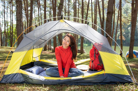 游客一位身穿红色衬衫露营的美女坐在黄色帐篷里背着红色包娱乐湖图片