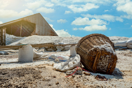 场地氯化物袋式有机海盐和竹篮在谷仓前的笼子里用蓝天和夏月白云蓝天和做成沙质工业用盐水袋中的海洋原料旅游图片