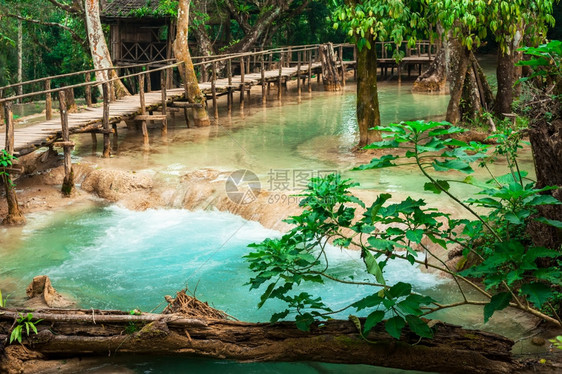热带雨林风景的角形热带雨林景观由木桥和老挝广西连级瀑布LuangPrabang的惊人绿水构成阳光河树图片