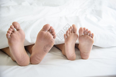 成人皮肤覆盖在蜜月度假期的卧室里赤脚裸在毯子下紧贴一对夫妇在蜜月假日的卧房里周末很长时间在家里婚礼仪式后与浪漫人士放松图片