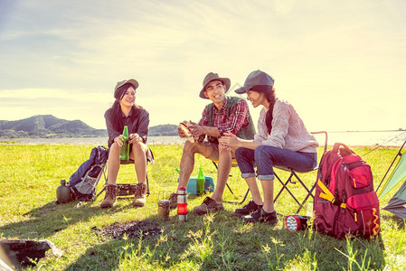一群露营者聊天在草地田野餐背景图片