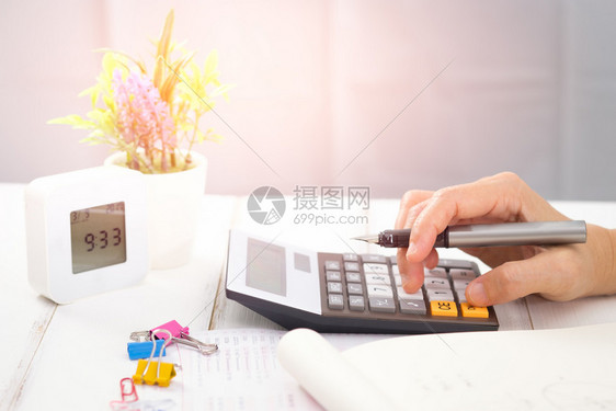 发票使用桌上计算器的女商人选择焦点在光线上税成功图片