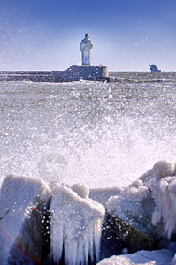 户外残酷的涂层寒冷灯塔和码头在暴风寒冬日图片