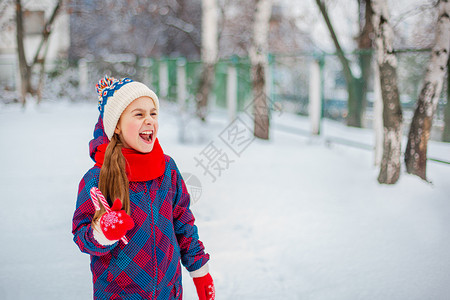 雪公平的灯一个可爱女孩的肖像圣誕棒糖在冬街上握手天街道上童子脸的有趣情调长着可爱女孩的肖像圣日棒糖在冬季街道上握手图片