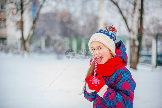 男生美味的童年一个可爱女孩的肖像圣誕棒糖在冬街上握手天街道上童子脸的有趣情调长着可爱女孩的肖像圣日棒糖在冬季街道上握手图片