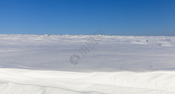 下着蓝天空深雪漂浮在一片蓝色的天空中在寒冷的天气中深雪漂流时间场景深的图片