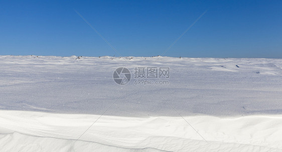 下着蓝天空深雪漂浮在一片蓝色的天空中在寒冷的天气中深雪漂流时间场景深的图片