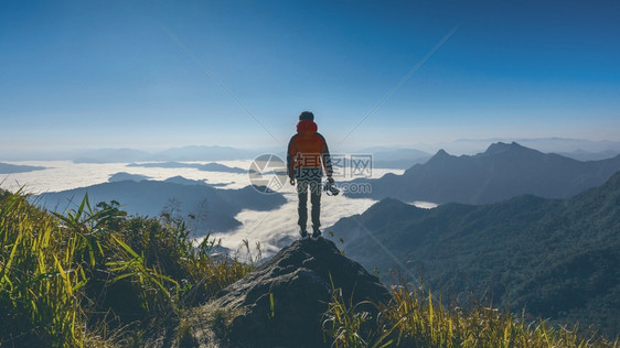 谷游客摄影手握着照相机站在自然中的岩石顶端旅行观音调概念原声图片