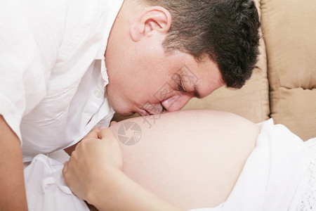 男人亲吻孕妇的胃部肖像关心未来图片