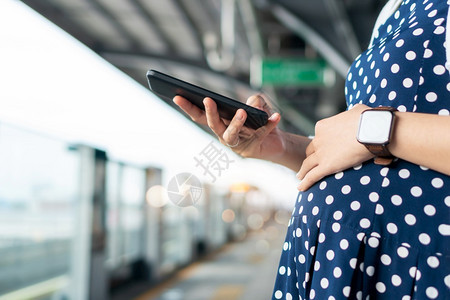 爱抚生活称呼孕妇在等候往返公共汽车或前往城市工作的火车中使用移动电话或智能时享有互联网技术在城市工作期间享受互联网技术的孕妇图片