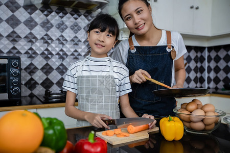 他们的亚洲家庭正在做饭父母女儿家里厨房做饭节假日的家庭活动和娱乐快概念是家庭活动在娱乐中欢的理念围裙父亲图片