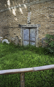 具体的棕色带旧砖墙和草地的锌门库存照片建造图片