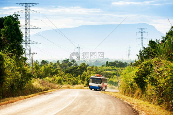 一辆当地公共汽车在南老挝博拉文高原的山路上向老挝和越南边境附近的城镇行驶其背景为黄昏时的闪光山力量一种当地的图片