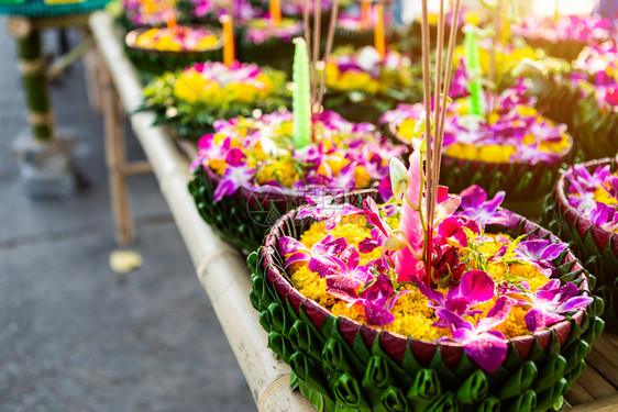经过传统的在泰国著名节日12月满泰式LoyKrathong庆典或泰国新年和河流女神礼拜仪式上由香蕉叶在泰国风格的兰花篮子上漂浮的图片
