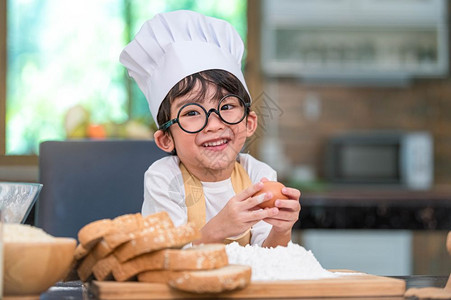 男生烹饪童年喜欢烘烤面包的亚洲小快乐男孩在家厨房里很滑稽人们的生活方式和家庭自制食物原料概念烤圣诞蛋糕和饼干人们的生活方式和家庭图片